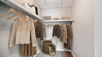 Walk in carpeted closet, wooden hangers, blouses and coats