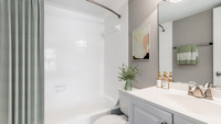 Bathroom, toilet, tub, curved shower rod, and blue curtain, large mirror