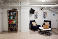 Well-appointed laundry room with seating and a shared bookshelf at a 55+ community on the Main Line.