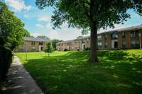 Apartment building exterior with landscaped grounds at Woodmere Apartments