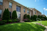 Apartment building exterior with landscaped grounds at Woodmere Apartments