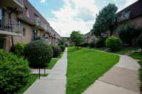 Peaceful green space surrounding Valley High Apartments with walking paths and mature trees