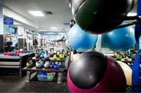 Modern fitness center featuring vibrant kettlebells, exercise balls, and state-of-the-art gym equipment, offering a dynamic workout environment.