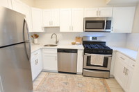 Modern kitchen with sleek stainless steel appliances, white cabinetry, and a stylish backsplash.
