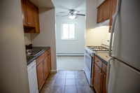 Cozy kitchen with elegant wooden cabinets, sleek countertops, and modern appliances, leading to a bright window-lit area.