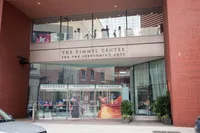 Elegant entrance to a modern performing arts center with large glass windows, contemporary design, and inviting banners advertising music and theater events.