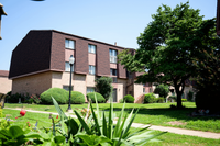 Charming apartment building with classic brick architecture, surrounded by lush greenery and well-maintained landscaping.