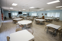 Bright and spacious community room with elegant tables and chairs, perfect for gatherings and events, featuring modern decor and ample natural light.