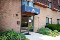 Inviting entrance of Delaire Landing, featuring a brick facade with lush landscaping and a charming awning.