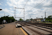 Charming outdoor railway station with scenic views, surrounded by lush greenery and a picturesque sky.
