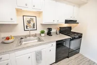 Charming modern kitchen with sleek white cabinets, stainless steel sink, and stylish appliances for a sophisticated touch.
