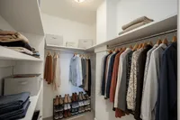 Elegant walk-in closet showcasing organized clothing racks, spacious shelving, and ample shoe storage.
