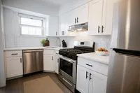 Modern kitchen with sleek stainless steel appliances, elegant white cabinetry, and a cozy breakfast nook.