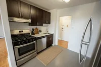 Modern kitchen with sleek stainless steel appliances, dark wood cabinetry, and contemporary tile flooring, creating a stylish and functional cooking space.
