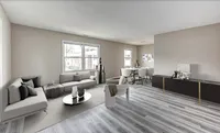 Bright and spacious living room with modern decor, featuring large windows, cozy sofas, and a chic dining area, perfect for elegant urban living.