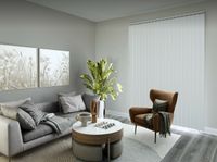 Chic modern living room with a stylish gray sofa, elegant artwork, and lush green plant accents, creating a cozy and inviting atmosphere.