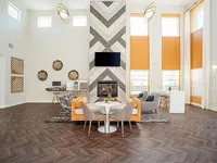 Sophisticated living area with high ceilings, a modern fireplace, and stylish seating, perfect for relaxation and entertaining.