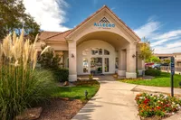 Inviting entrance of Allegro at Tanoan with lush landscaping and a welcoming pathway.