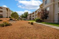 Inviting apartment complex with scenic landscaping, featuring stylish buildings under a bright blue sky, offering a harmonious living environment.