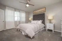Luxurious bedroom with a tufted headboard, elegant bedding, and soft lighting, perfect for relaxation.