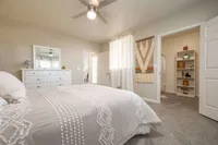 Cozy bedroom with elegant decor, featuring a stylish dresser, soft bedding, and a spacious walk-in closet.
