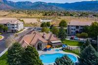 Gorgeous apartment complex with a sparkling blue pool, surrounded by lush greenery and mountain views, offering a tranquil and luxurious living experience.