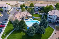 Inviting aerial view of a modern apartment complex with a stunning pool, vibrant landscaping, and ample parking.