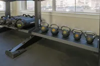 Modern fitness room showcasing a sleek set of kettlebells and weighted foam rollers, perfect for diverse workout routines.