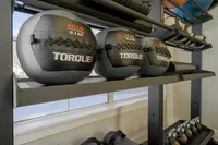 Modern gym features sleek shelves with Torque USA medicine balls and kettlebells, ideal for dynamic workouts in a fitness-focused space.
