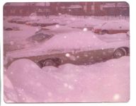 Nostalgic winter scene of a snow-covered parking lot with buried cars, capturing a serene and quiet beauty.