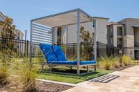 Inviting outdoor area featuring modern lounge seating under a stylish pergola, perfect for relaxation amidst lush greenery.