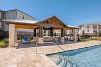 Inviting outdoor pool area with a stylish pergola and modern apartment backdrop, perfect for relaxation and social gatherings.