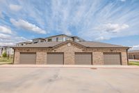 Charming brick garage units under a clear blue sky, providing ample storage and convenience for modern living.