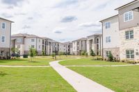 Charming apartment complex nestled in lush greenery, featuring modern architecture and inviting pathways.