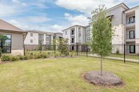 Inviting apartment complex with modern architecture, lush landscaping, and ample outdoor space.