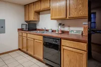 Inviting kitchen with wooden cabinets, modern appliances, and tile flooring.