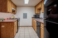 Inviting kitchen with wooden cabinetry, modern appliances, and tiled flooring.