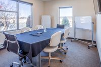 Meeting Room Vibrant meeting room with large windows, conference table, and office chairs.