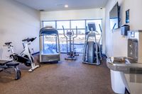 Fitness Center Bright gym space featuring modern exercise equipment, including spin bike, treadmill, and elliptical.