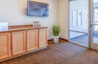 Lobby Cozy lobby area with a wooden cabinet, modern decor, and a large window letting in natural light.