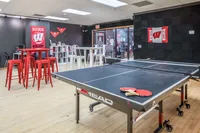 Dynamic lounge area featuring a ping pong table, vibrant red stools, and a modern study nook with Wisconsin decor.