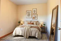 Inviting bedroom featuring a cozy bed with plush pillows, soft lighting, and elegant wall art creating a serene atmosphere.