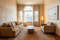 Inviting living room with large windows offering a stunning city view, featuring elegant neutral decor, cozy seating area with plush sofas, and ambient lighting.