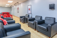 Modern lounge area with sleek black armchairs and vibrant red accents, perfect for relaxing or social gatherings.