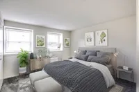Bright Meadows Townhomes bedroom showcasing a gray bed paired with a sleek white dresser for a modern touch.