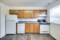 A bright kitchen featuring a refrigerator, stove, and microwave at Bright Meadows Townhomes.