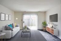 Welcoming living room at Bright Meadows Townhomes, featuring a couch, coffee table, and television for a perfect hangout spot.