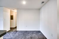 Bright and inviting room in Allyson Gardens Apartments II, showcasing plush carpet and clean white walls for a fresh look.