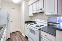 Allyson Gardens Apartments II kitchen with clean white appliances and a contemporary refrigerator.