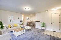 A tidy living room in Allyson Gardens Apartments II featuring a couch, coffee table, and television for a cozy atmosphere.